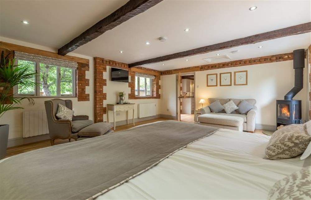 Open plan bedroom/sitting room with beamed ceiling at The Old Cow Shed, Pott Row near Kings Lynn