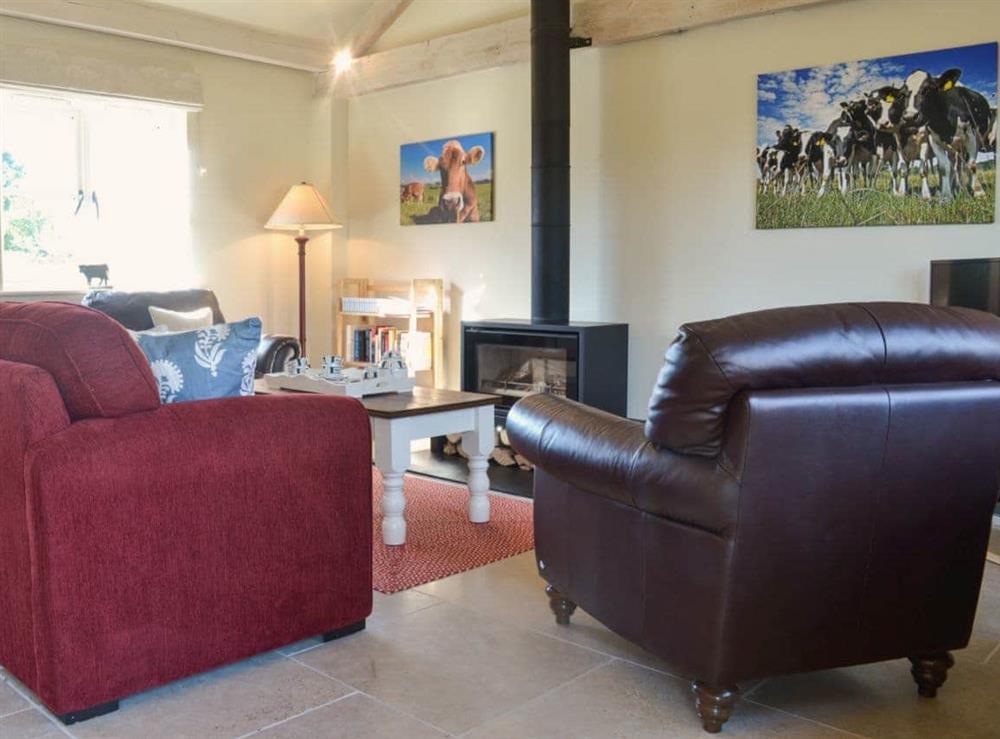 Lounge area with wood burner at The Old Cowshed in Hornblotton, near Glastonbury, Somerset