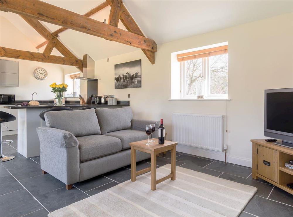 Spacious open plan living space, with beamed ceiling at The Old Dairy in Cam, near Dursley, Gloucestershire, England