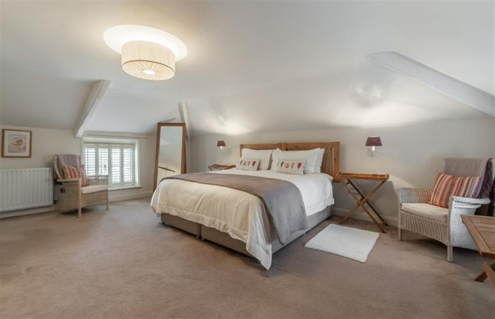 First floor: Master bedroom with a king-size bed at The Old Dairy, Great Bircham near Kings Lynn