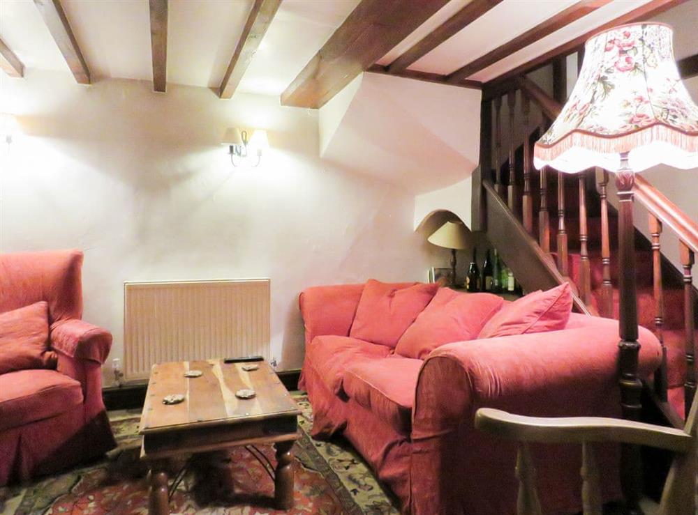 Beamed living room with staircase to the first floor at The Old Dairy in Youlgreave, near Bakewell, Derbyshire