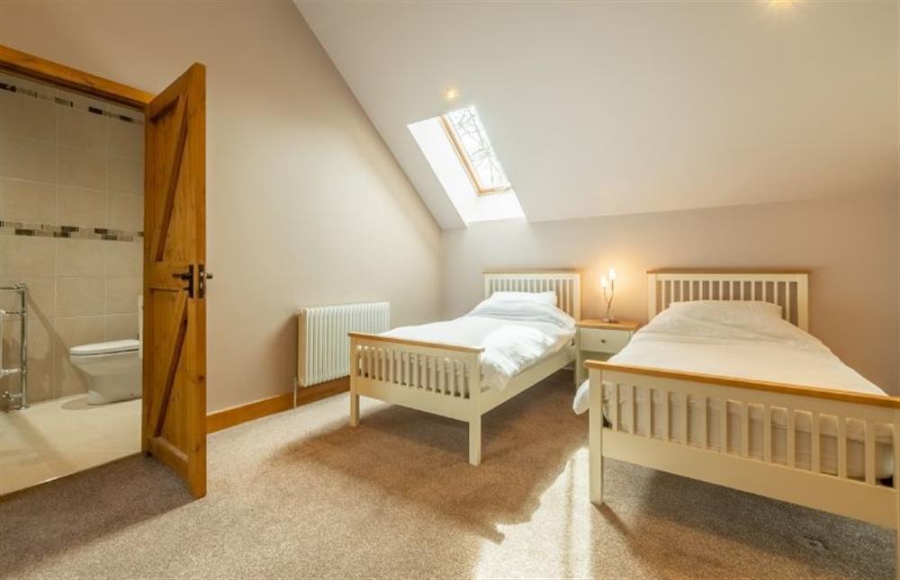 First floor: Bedroom four with door to en-suite at The Old English Barn and Cart Shed, Paston near North Walsham