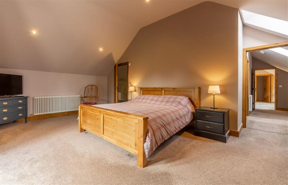 First floor: Bedroom two with door to en-suite at The Old English Barn and Cart Shed, Paston near North Walsham