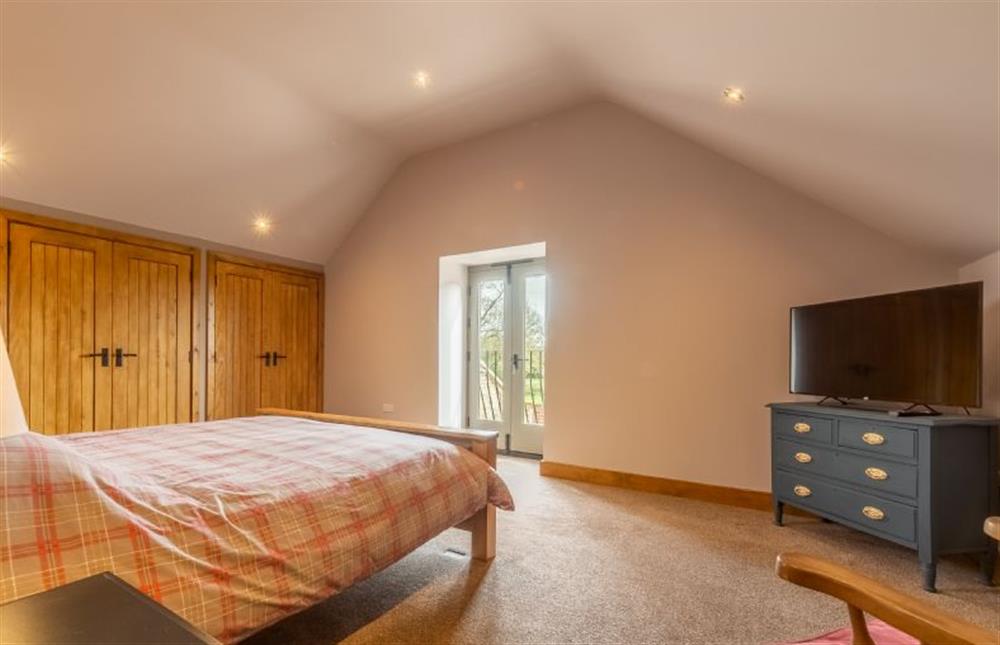 First floor: Bedroom two with king-size bed, Smart television and Juliette balcony at The Old English Barn and Cart Shed, Paston near North Walsham