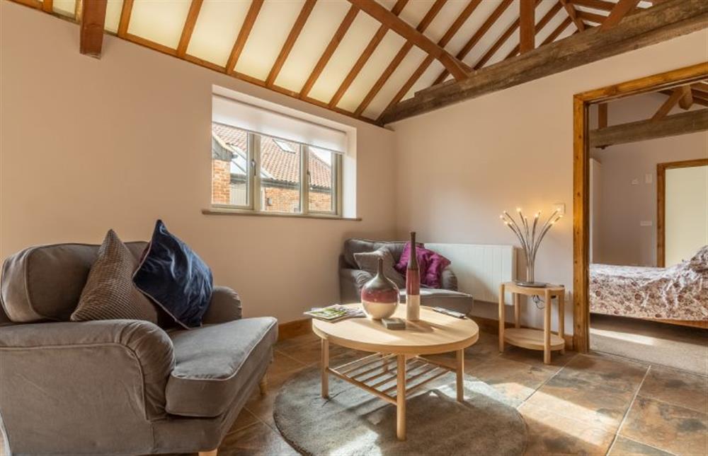 Ground floor: Sitting room area with door to master bedroom at The Old English Barn and Cart Shed, Paston near North Walsham