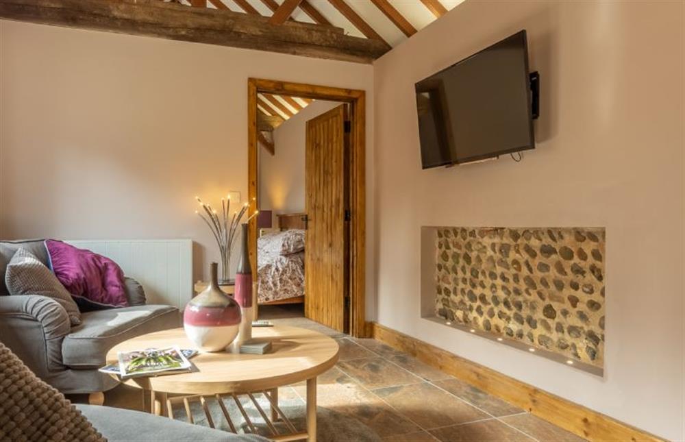 Ground floor: Sitting room area with Smart TV and door to master bedroom at The Old English Barn and Cart Shed, Paston near North Walsham