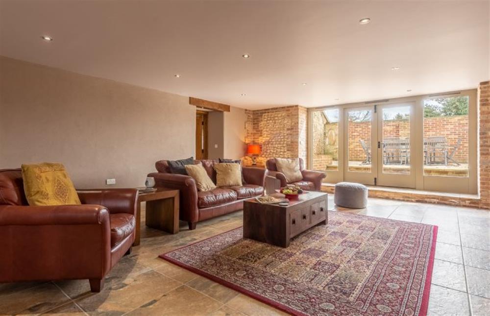 Ground floor: Sitting room with doors to courtyard  at The Old English Barn and Cart Shed, Paston near North Walsham