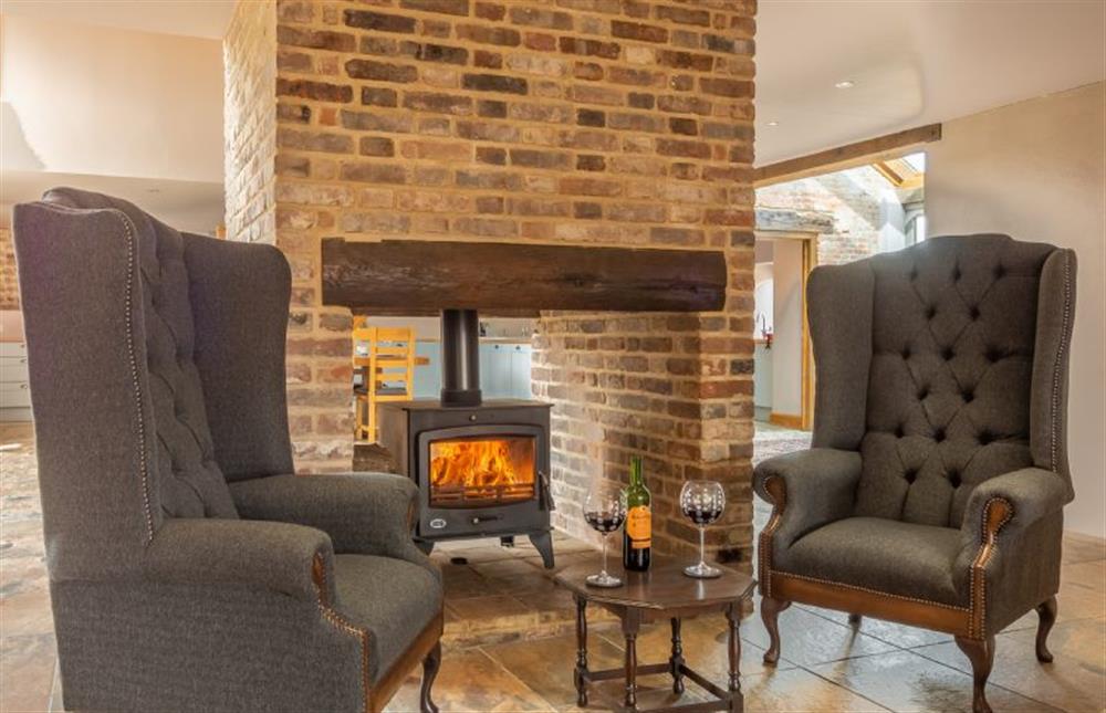 Ground floor: Sitting room with double-sided wood burning stove  at The Old English Barn and Cart Shed, Paston near North Walsham