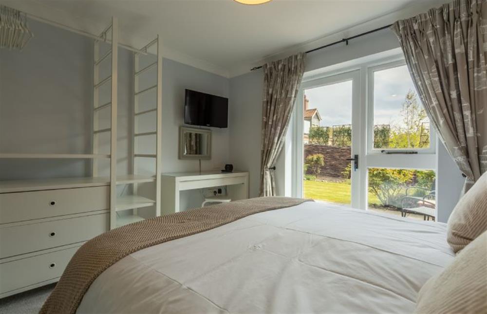 Ground floor:  Master bedroom with open hanging rail and shelving at The Old Joinery, Cley-next-the-Sea near Holt
