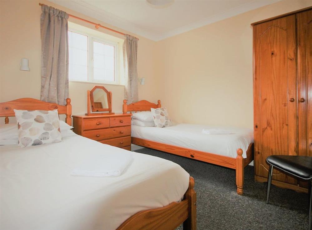 Spacious bedroom with double and single beds at Tom Putt, 