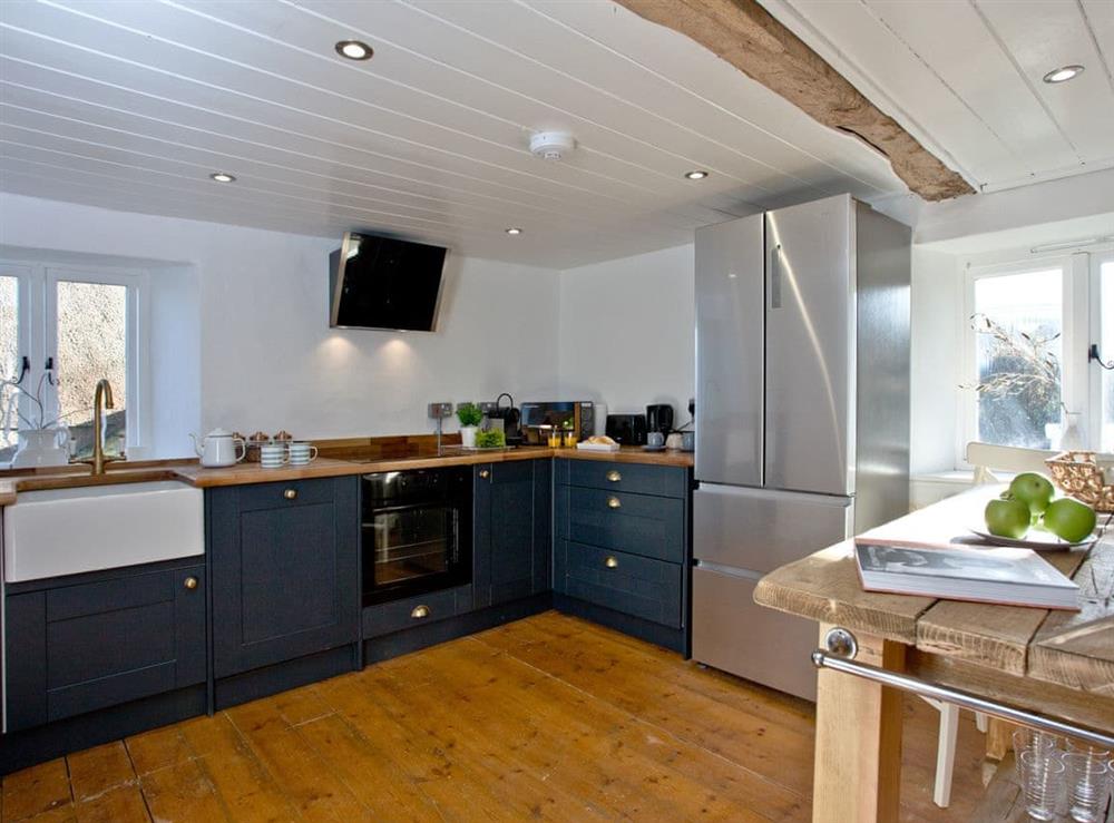 Fully equipped kitchen with dining area within the open-plan design at The Old Mill in Egloskerry, near Launceston, Cornwall