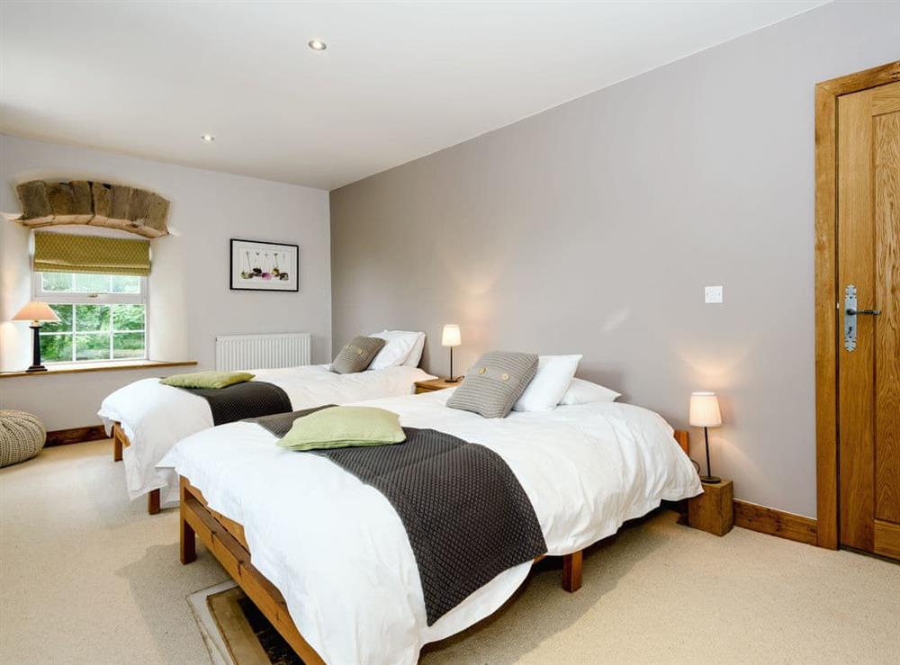 Comfortable bedroom with two double beds at The Old Mill in Penrith, Cumbria