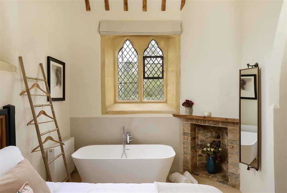 Ground floor: Bedroom one with 5ft king-size bed, free-standing bath, original ornamental fireplace and original mullion windows
