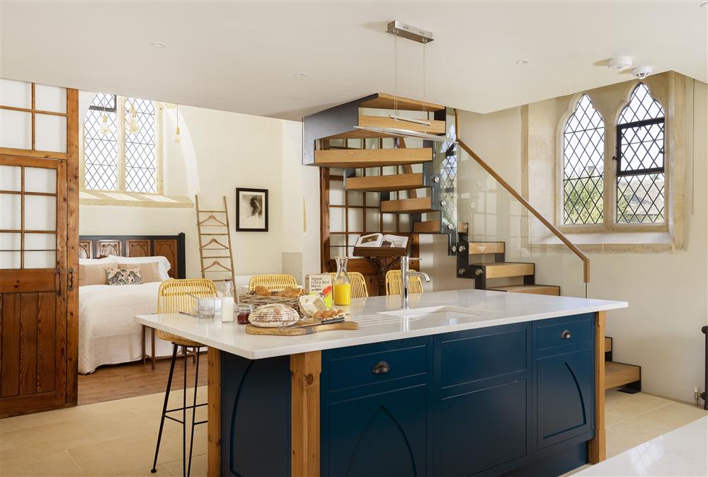 Ground floor: Open-plan kitchen with sliding doors leading to bedroom one at The Old Mission Church, Paxford, near Chipping Campden