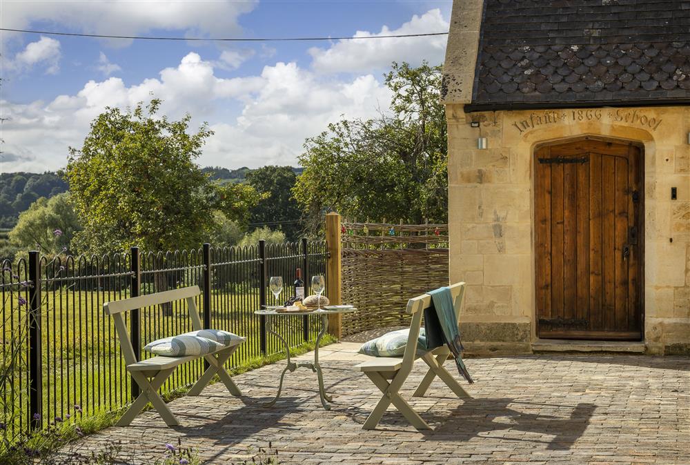 The pretty front patio, complete with painted pews at The Old Mission Church, Paxford, near Chipping Campden