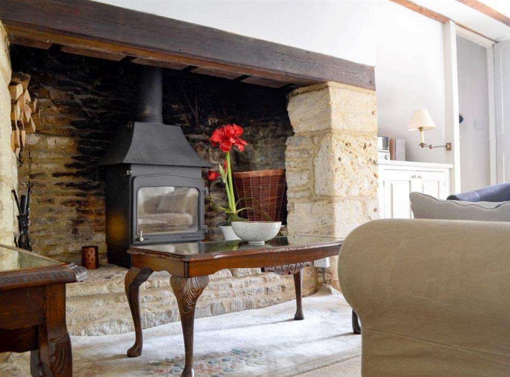 Cosy wood burner in the living room at The Old Post Office in Chedworth, near Cheltenham, Gloucestershire