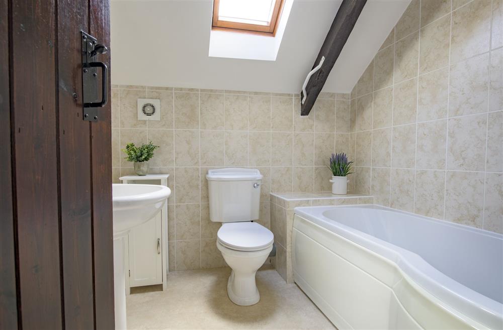 Family bathroom with P-shaped bath and hand-held shower overhead at The Old Potting Shed, Kirkbymoorside, York, North Yorkshire