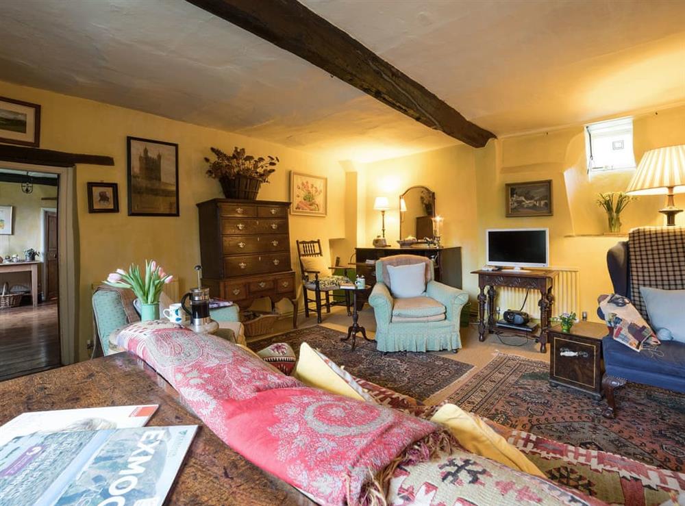 Cosy living room with wood burner at The Old Priory Cottage in Dunster, near Minehead, Somerset