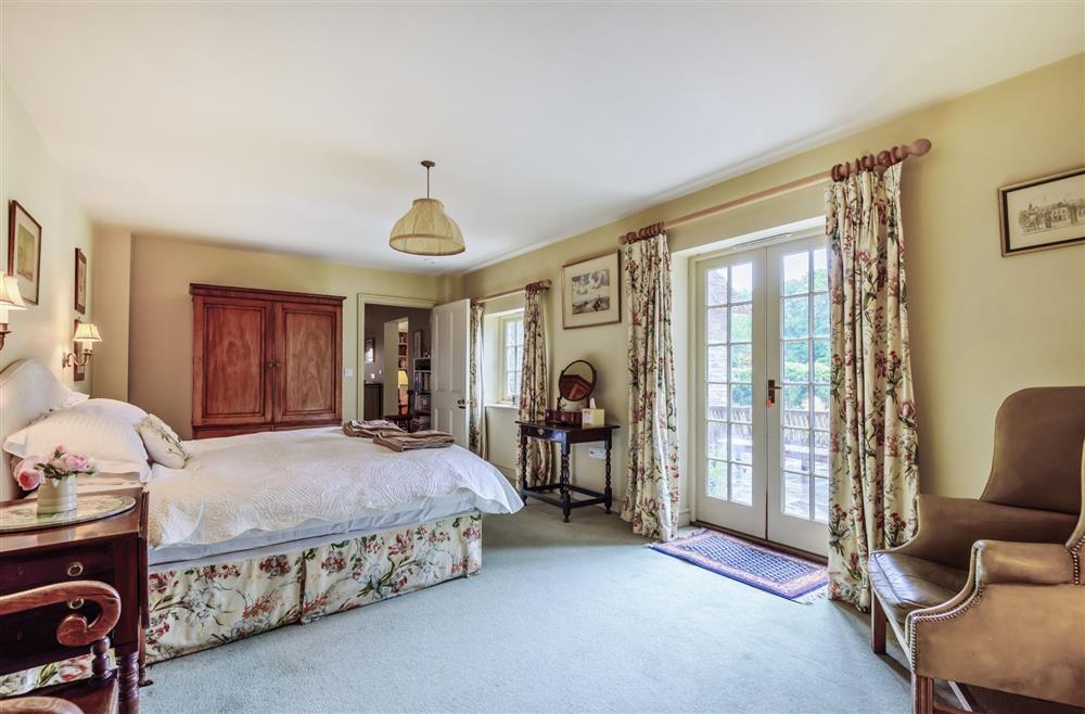 Bedroom one with doors to the garden at The Old Rectory Lodge, Dorchester
