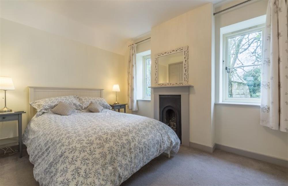 First floor: Bedroom three, king-size bed and feature fireplace at The Old School House, Docking near Kings Lynn
