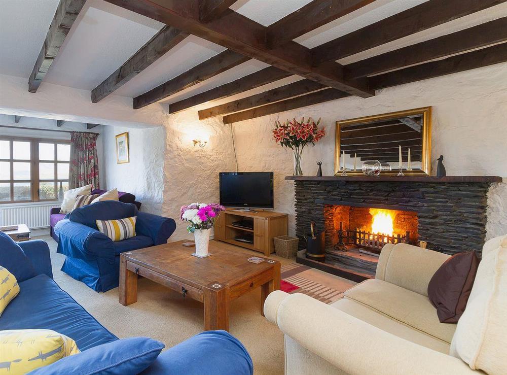 The beamed living room with an open fire has a 42 inch Freeview tv at The Old Smithy in Appin, Argyll