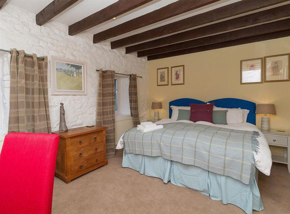 The second bedroom is well decorated and has whitewashed stone walls and beams at The Old Smithy in Appin, Argyll