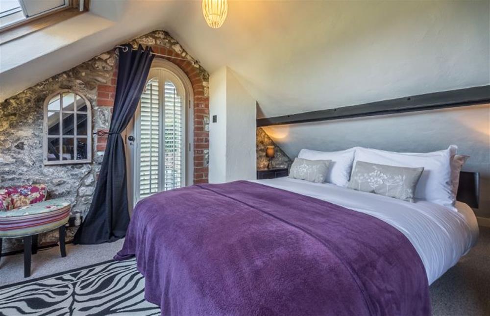 First floor: King-size bed in large vaulted room  at The Old Smithy, Holme-next-the-Sea near Hunstanton