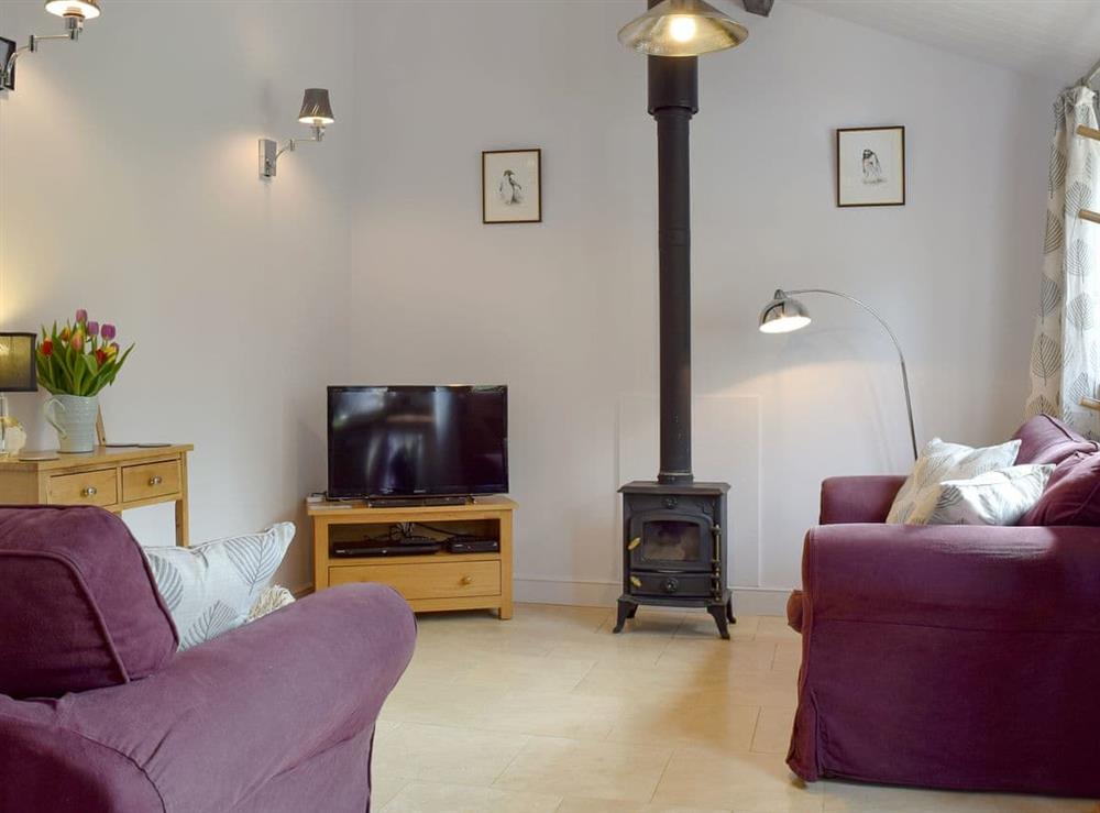 Attractive living area with cosy wood burner at The Old Stables in Swerford, near Chipping Norton, Oxfordshire