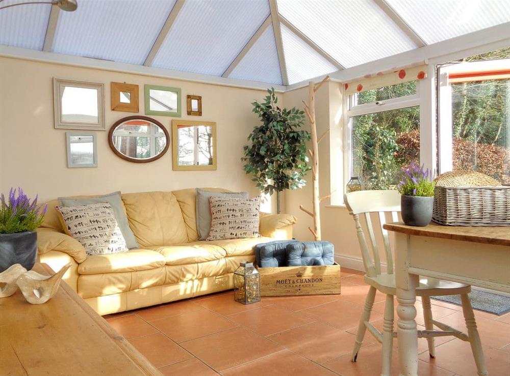 Comfy seating area within conservatory at The Old Winery Cottage in Newent, Gloucestershire