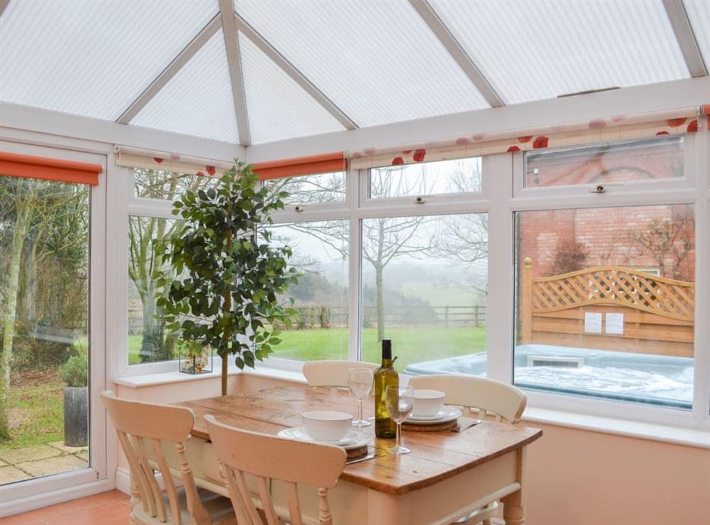 Conservatory with dining area at The Old Winery Cottage in Newent, Gloucestershire