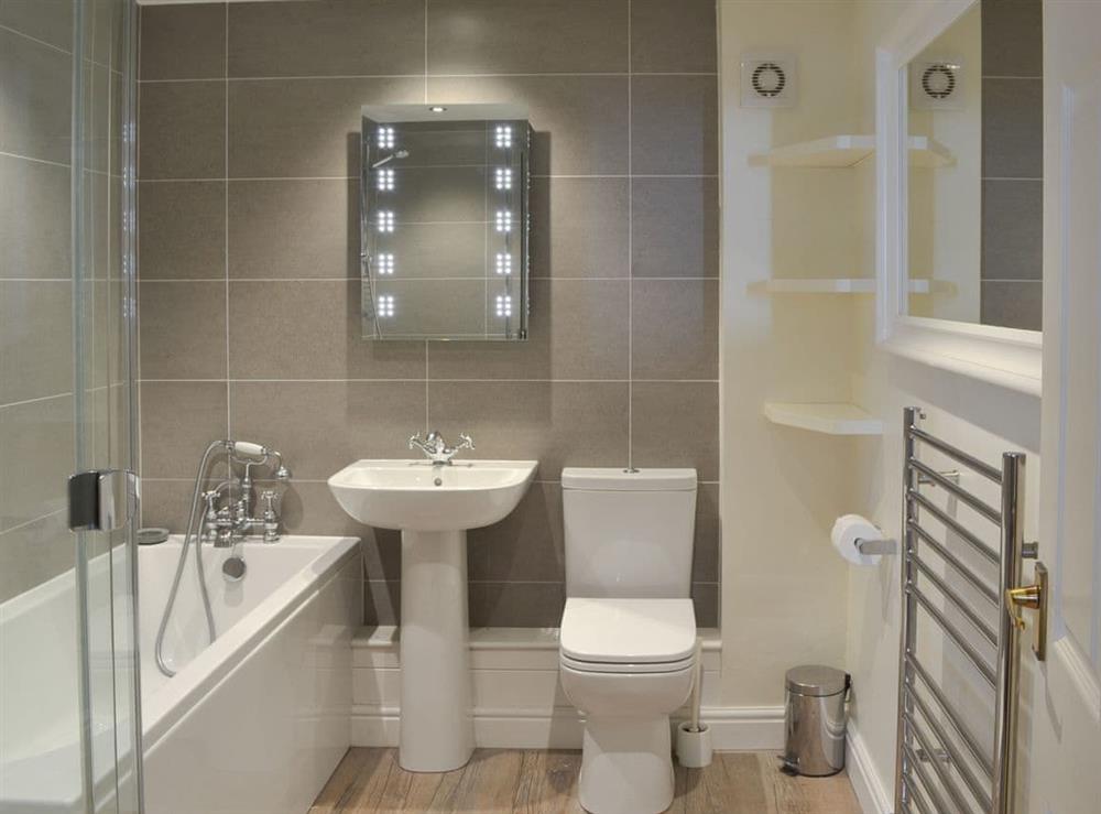 Beautifully tiled and well appointed bathroom with shower over bath at The Old Woodyard in Kendal, Cumbria