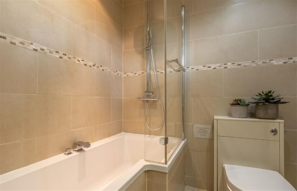 The Orangery: The bathroom has a bath with shower over, WC, basin and mirror (photo 3) at The Orangery, Snettisham near Kings Lynn