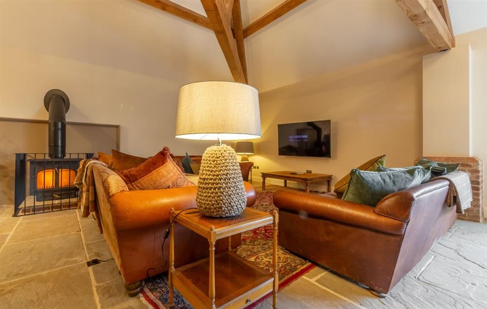 Spacious open plan sitting room with wood burning stove (photo 2) at The Owl House, Little Massingham