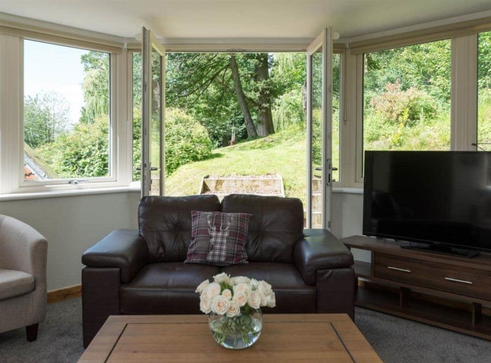 Sun room with French doors leading to garden at The Pamper Lodge in Sleights, near Whitby, North Yorkshire