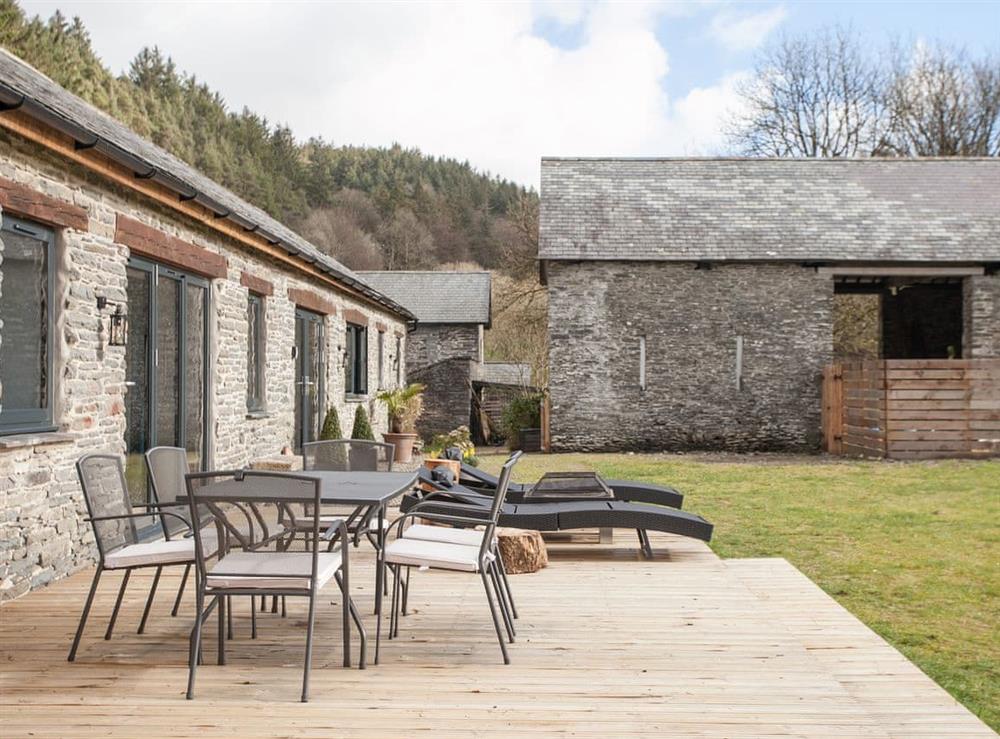 Decked patio area with table and chairs at The Pendre Longbarn in Pontrhydygroes, near Ystrad Meurig, Cardigan, Dyfed