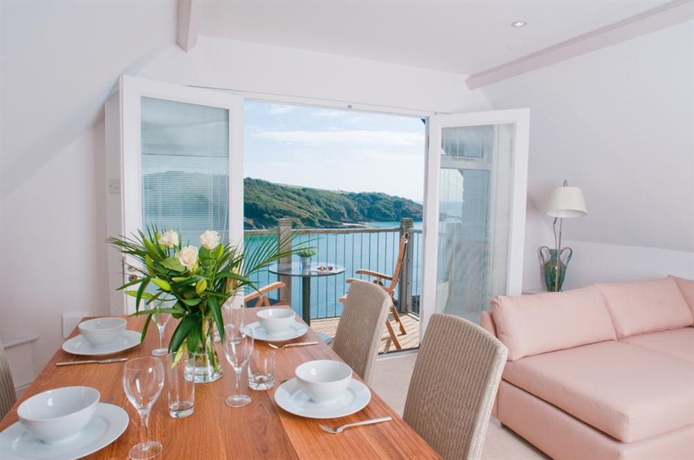 A light and sunny lounge/dining room with doors to the balcony at The Penthouse (Woodside) in Bennett Road, Salcombe