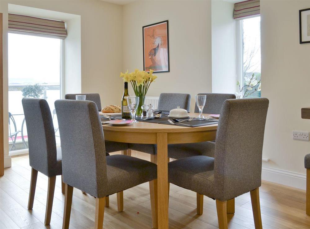 The family dining table is overlooked by large floor to ceiling windows letting in lots of light