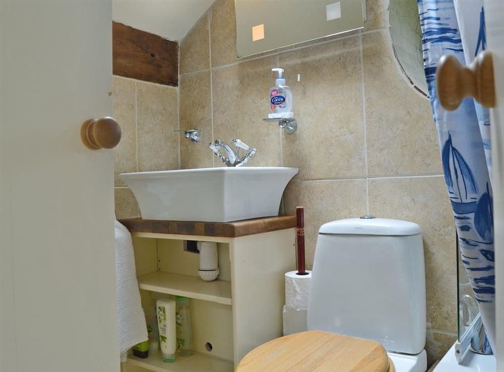 En-suite bathroom with shower over bath at The Pigsty Cottage in Oswestry, Shropshire