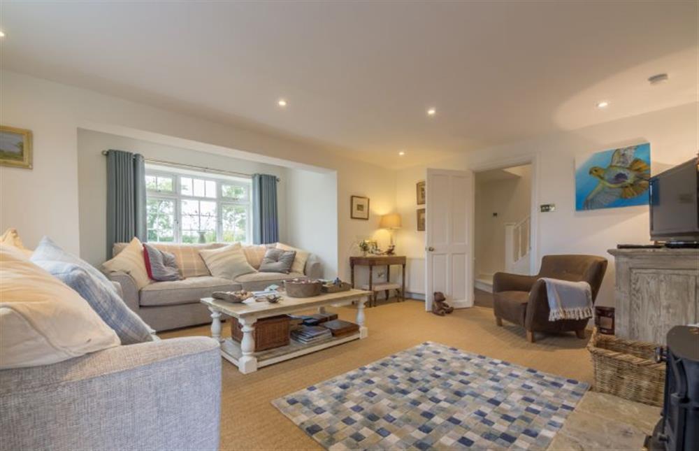Ground floor: Large sunny dual aspect sitting room with feature fireplace with wood burning stove