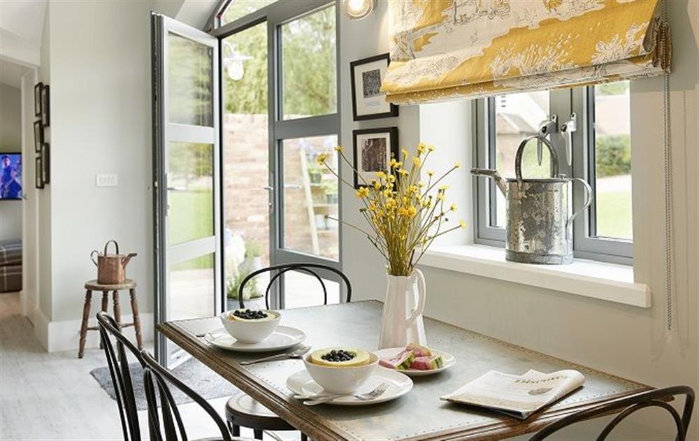 Open plan dining room with french doors to outside patio at The Potting Shed, Weston-under-Lizard, Shifnal 