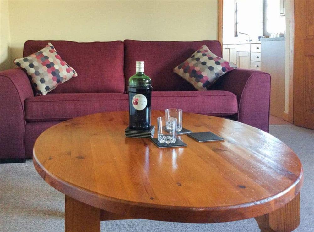 Relax and unwind in the warm and welcoming living room at The Pump House in Hawkesbury Upton, Avon