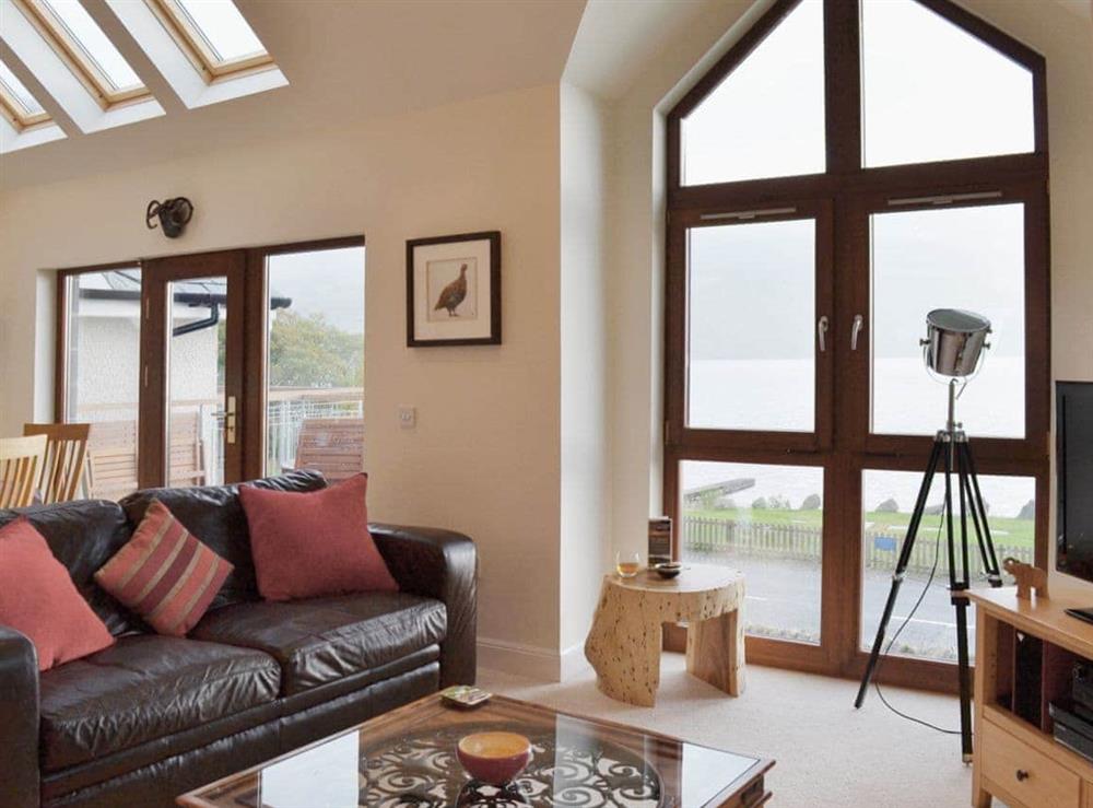 Large open plan living area with patio doors leading onto the balcony at The Quaich in Fearnan, by Aberfeldy, Perthshire