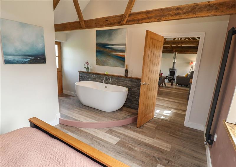 Bedroom with a stand-alone bath at The Roost, Porthallow