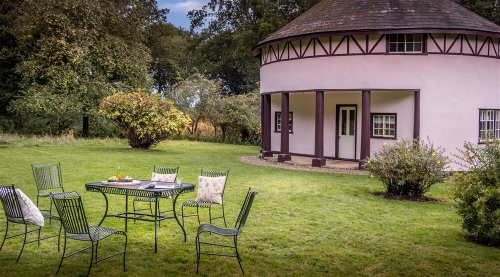 The large, lawned garden with outdoor dining furniture at The Round House in Bury St Edmunds, Suffolk