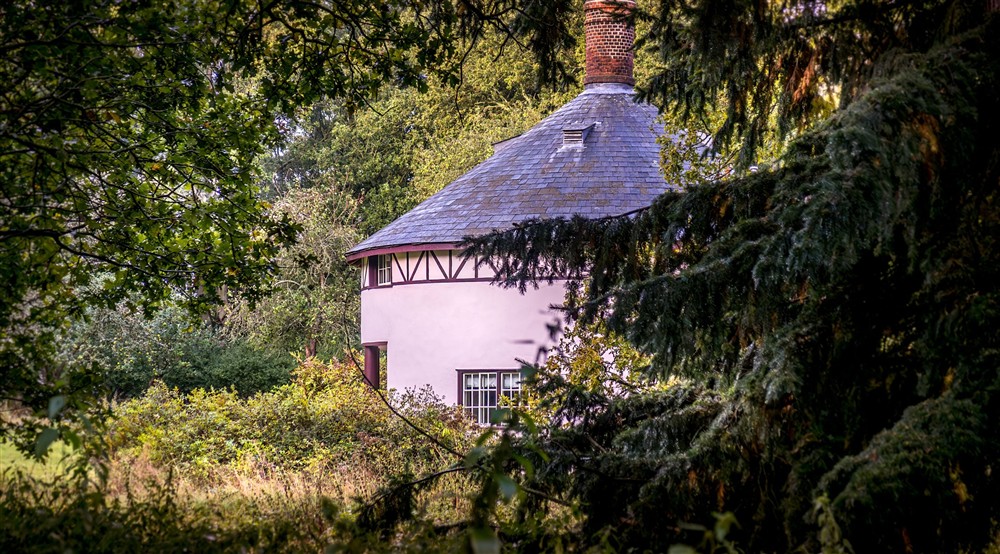 The Round House, peeking through the surrounding woodland, Suffolk at The Round House in Bury St Edmunds, Suffolk
