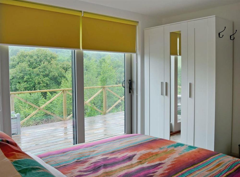 Comfortable double bedroom with doors leading to patio (photo 2) at The Shed with a View in Cadbury, near Crediton, Devon
