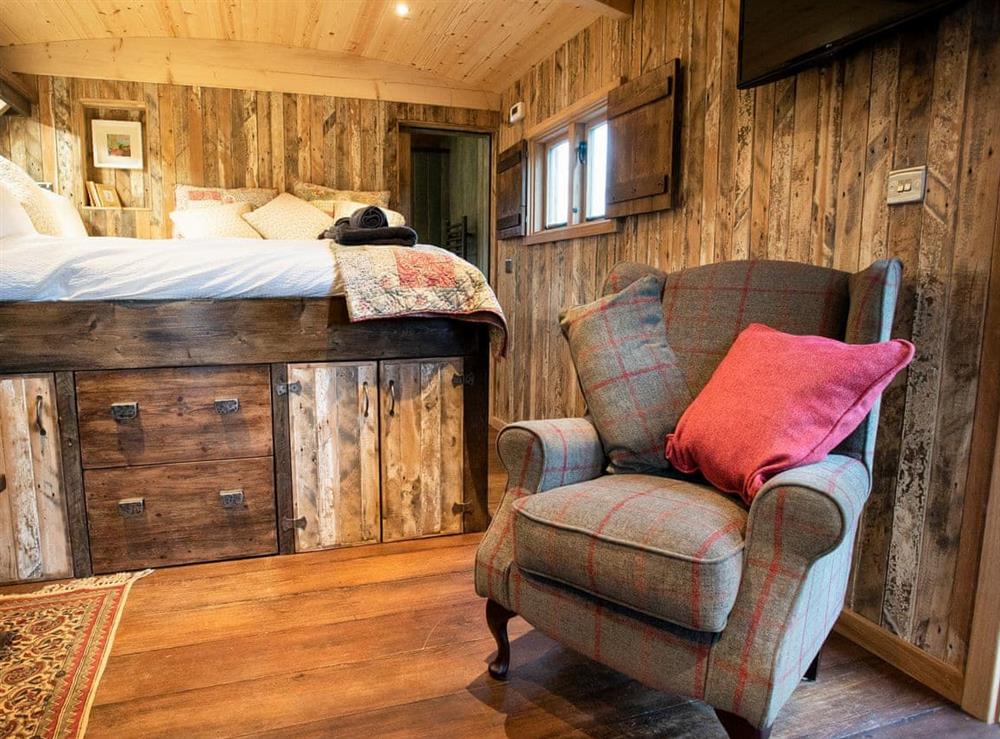 Bedroom area with double bed at The Shepherds Hut at Gowan Bank Farm in Ings, near Windermere, Cumbria