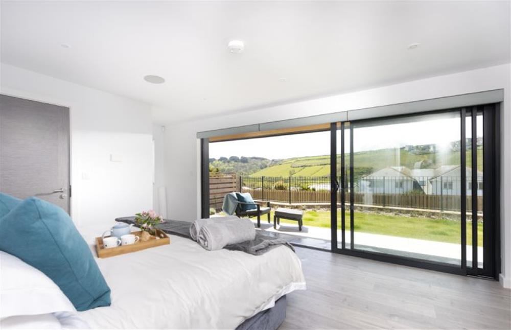 Bedroom one on the ground floor with a super-king size bed and sun terrace at The Shore, Mawgan Porth
