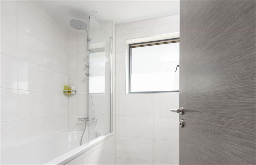 Family bathroom on the ground floor with bath and overhead shower at The Shore, Mawgan Porth