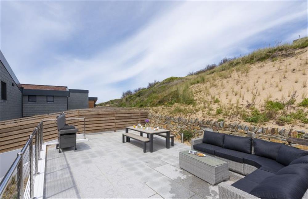Rear patio with raised seating and barbecue area at The Shore, Mawgan Porth